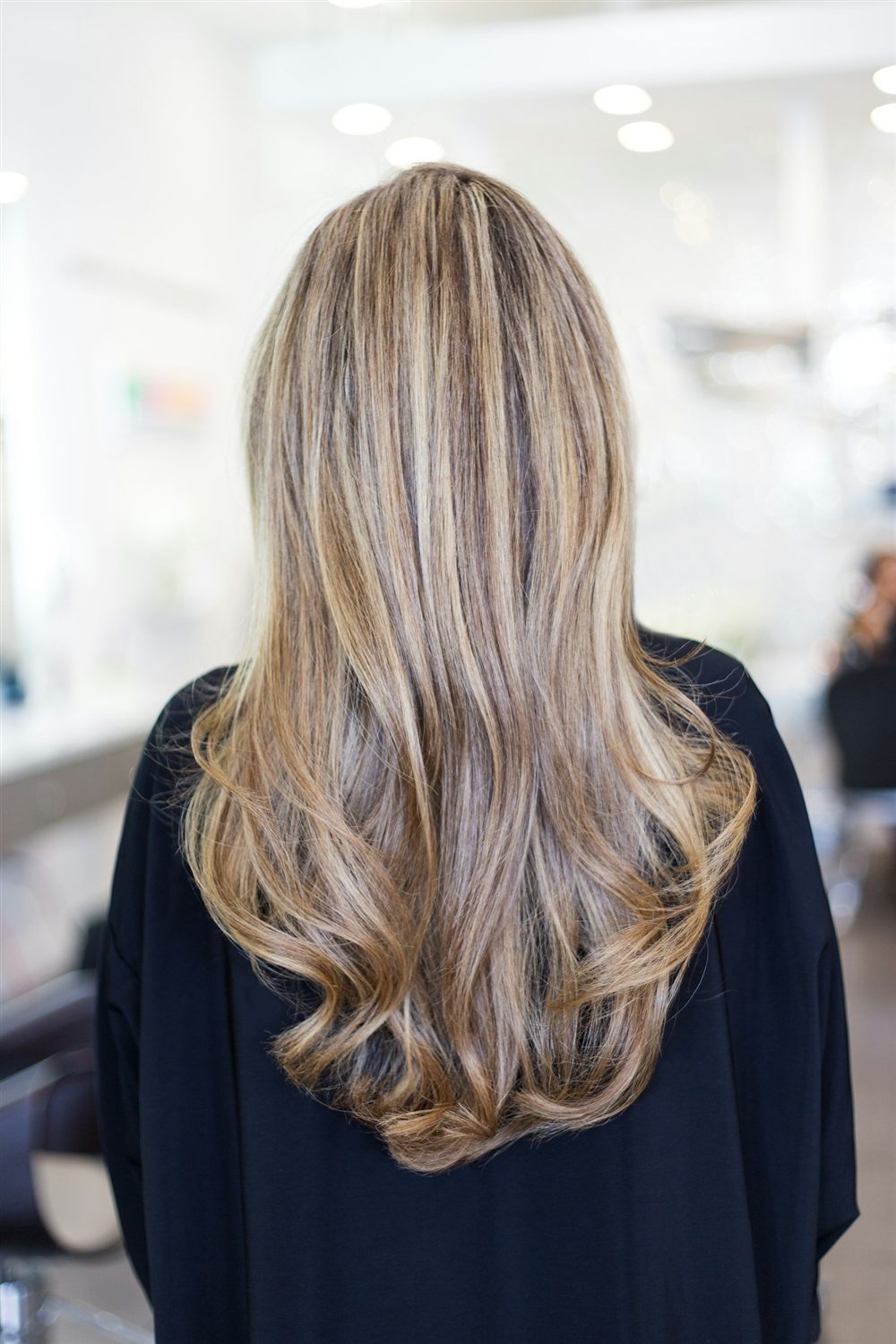 Cabello largo con mechas claras, visto de espaldas, sano y brillante
